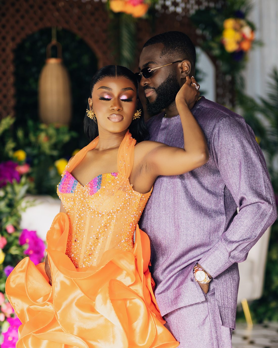 A couple in orange and lilac at their celebration